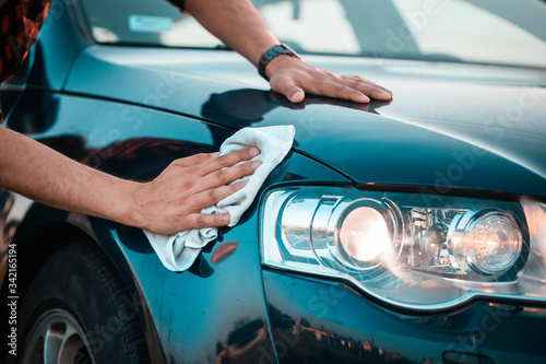 Shoot of a male hands carefully polishing his car with a microfiber cloth