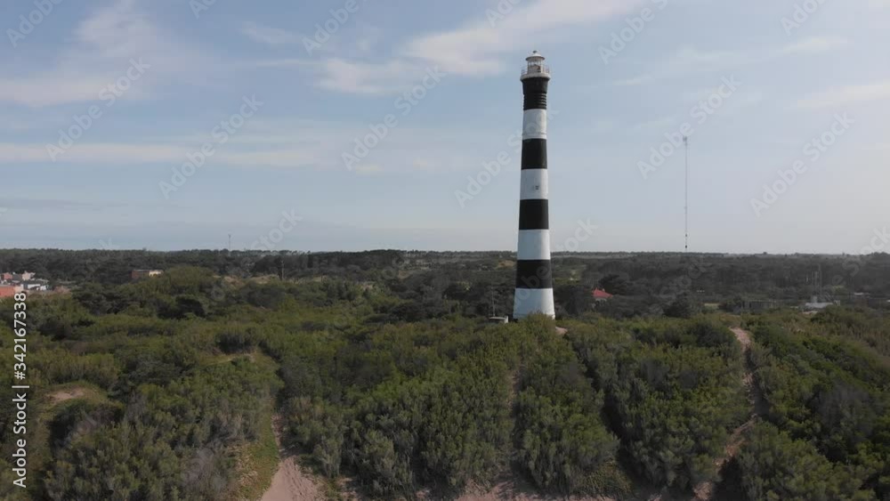 Aerial view of a lighthouse near the sea. Trees and vegetation around it Aerial view of a lighthouse near the sea. Trees and vegetation around it