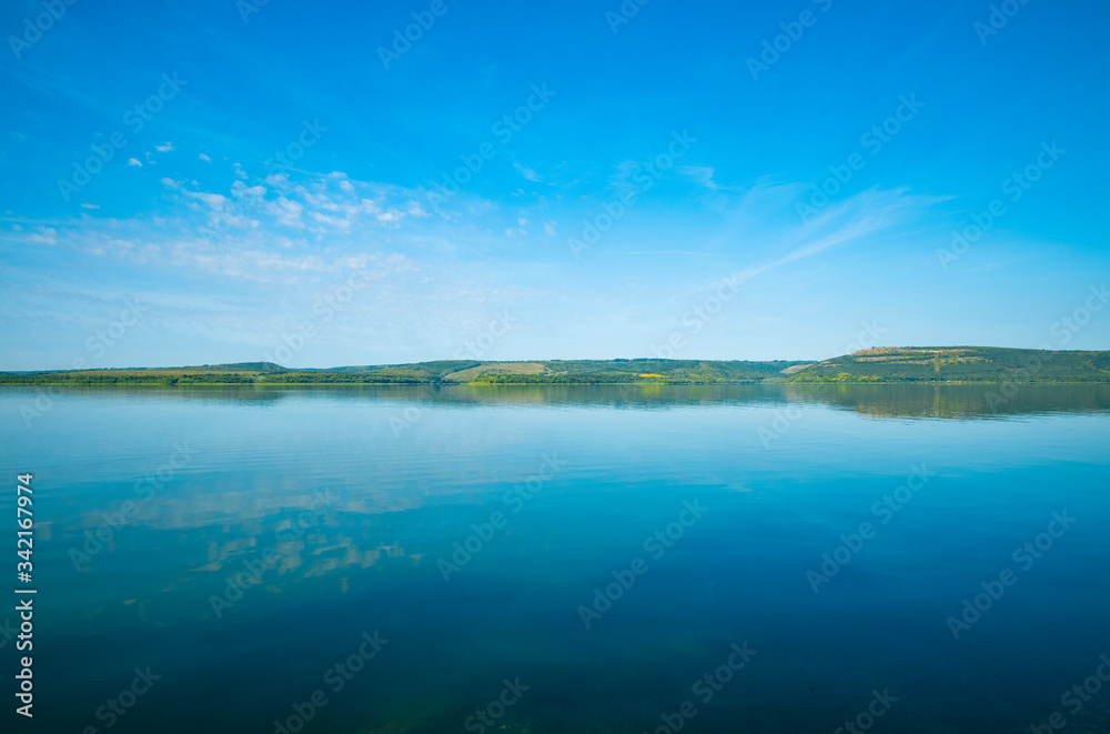 landscape wallpaper idyllic nature view of peaceful water surface foreground and horizon shore line of calm clear weather summer day time in August