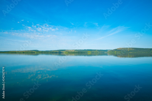 landscape wallpaper idyllic nature view of peaceful water surface foreground and horizon shore line of calm clear weather summer day time in August
