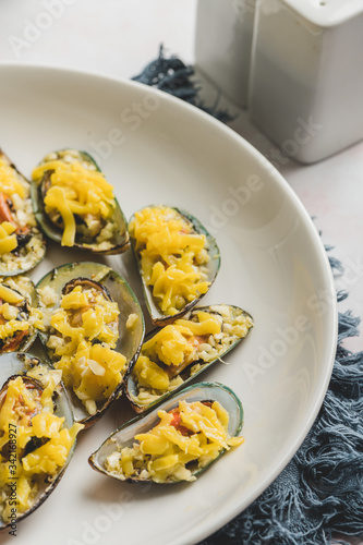 Stuffed Baked Mussels  (Baked Tahong) with Butter, Cheese and Garlic - Close up with pepper and salt shaker photo