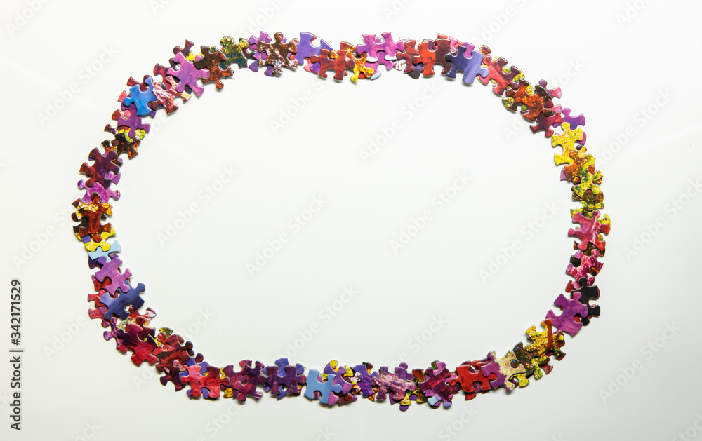 Fototapeta premium Puzzle pieces creating oval frame isolated on white background