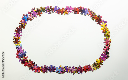 Puzzle pieces creating oval frame isolated on white background