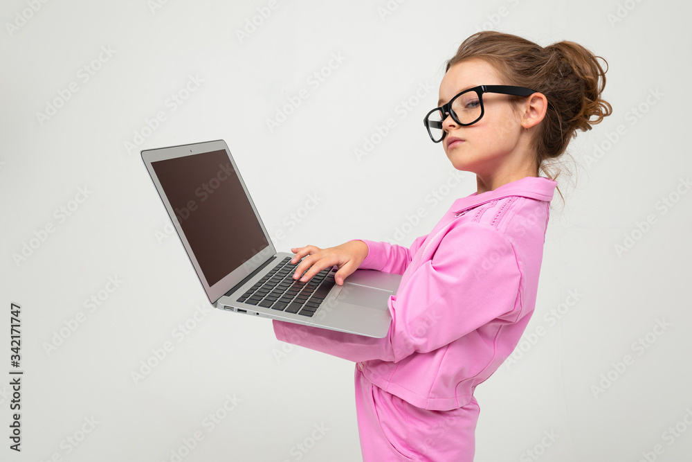 serious attractive girl with glasses in a pink suit with a laptop with a mockup on a white studio background serious attractive girl with glasses in a pink suit with a laptop with a mockup on a white studio background