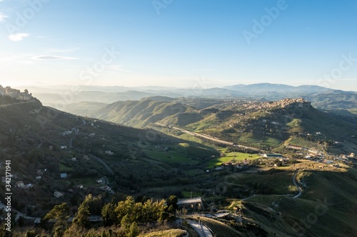 Wide-angle shot of Sicilian landscape with the city of Calascibetta at nice sunset with shadow of Enna city
