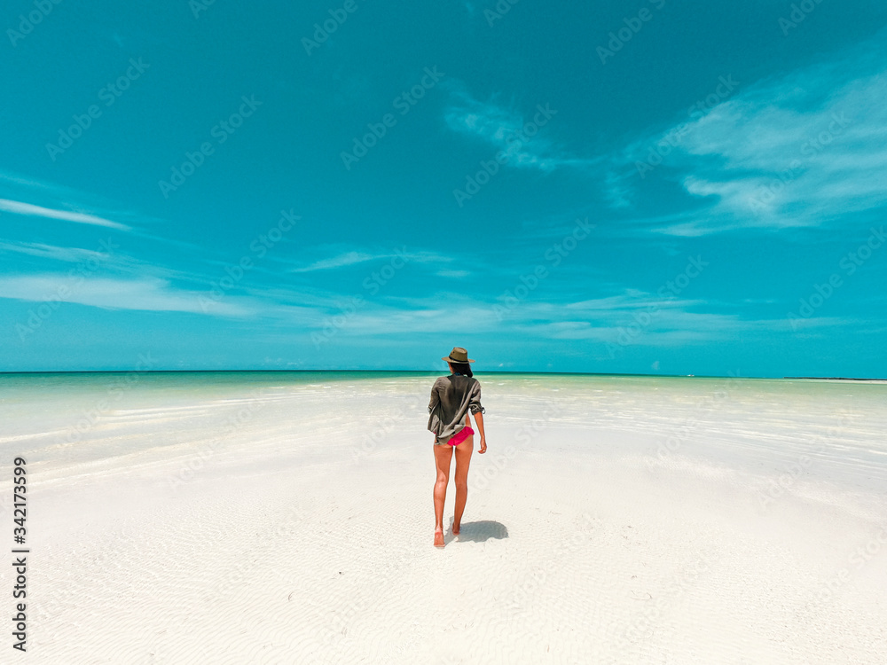 Mujer caminando en bancos de arena Isla Holbox