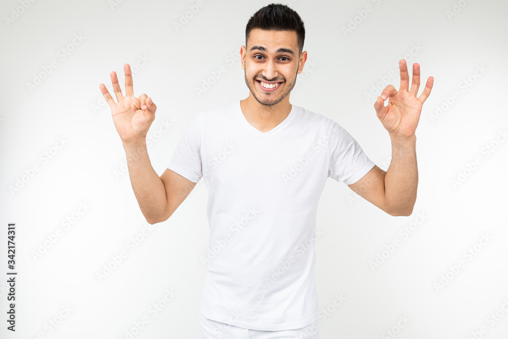 Naklejka premium smiling guy in a white t-shirt with a mockup on a white background