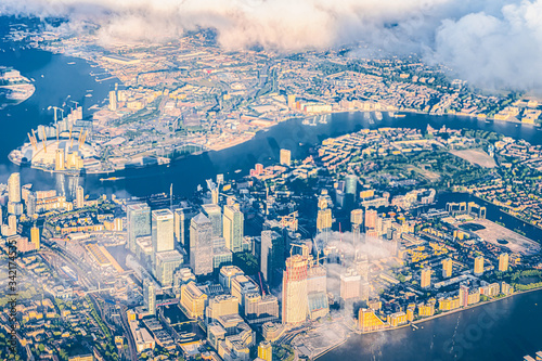 Aerial high angle bird's eye view from airplane over city of London Canary Wharf in United Kingdom with terraced houses buildings and cityscape skyscrapers