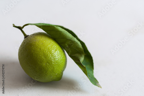 Green lemon with fresh leaf