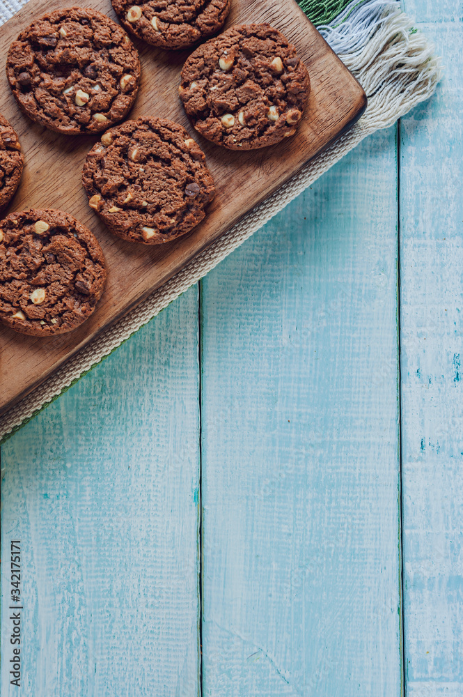 Chocolate cookies with a glass of milk on the light green wooden table in top view Chocolate cookies with a glass of milk on the light green wooden table in top view