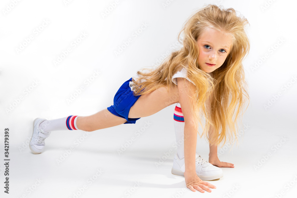 young little blonde girl is stretching on a white background young little blonde girl is stretching on a white background