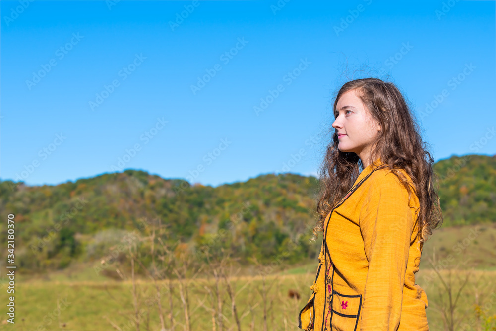 Autumn fall in farm countryside of Virginia with green blue ridge appalachian mountains and side profile of young woman looking at view thinking of relocation in Bath county