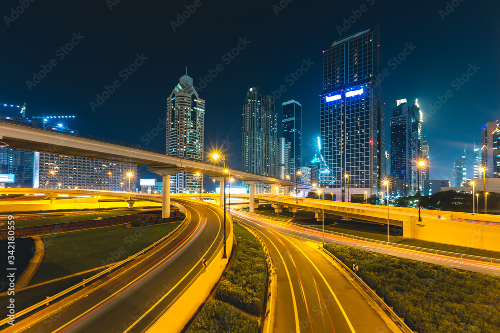 Long exposure of cars passing on highway at night in front of skyscrapers Dubai - UAE