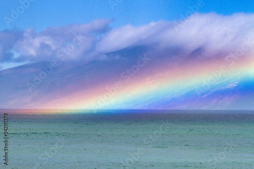 Electric rainbow hovering over the ocean on Maui. © manuel