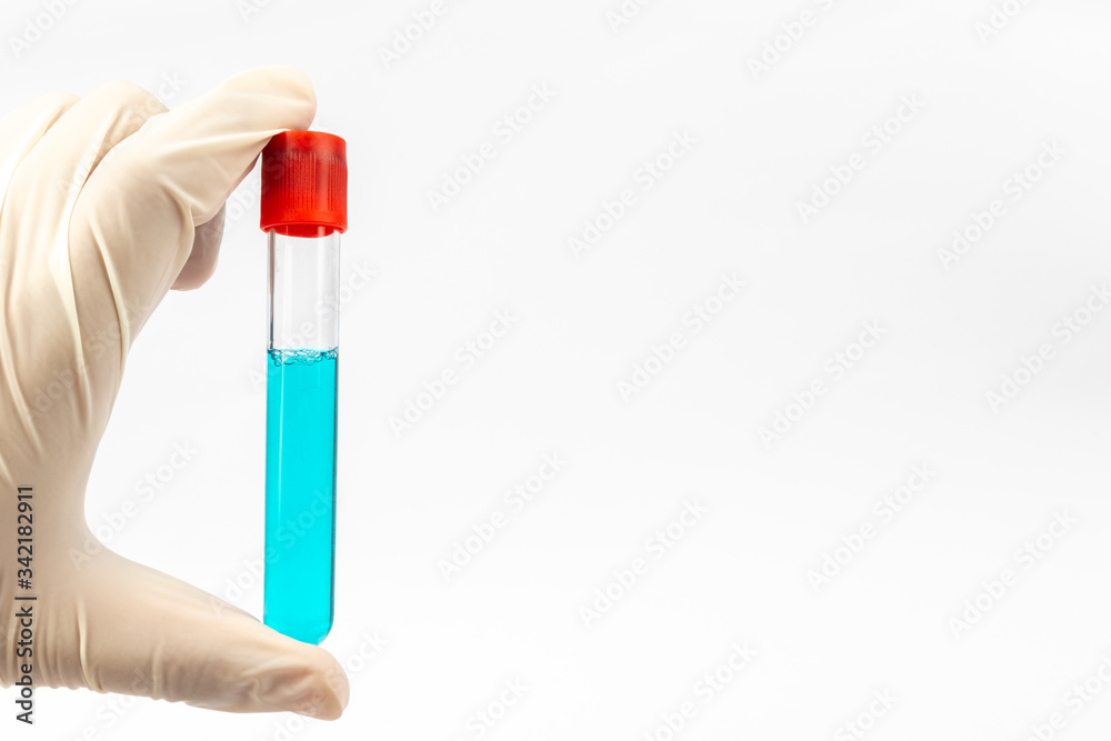 Hand with medical glove holding Medical test tube with blue liquid on white background Hand with medical glove holding Medical test tube with blue liquid on white background