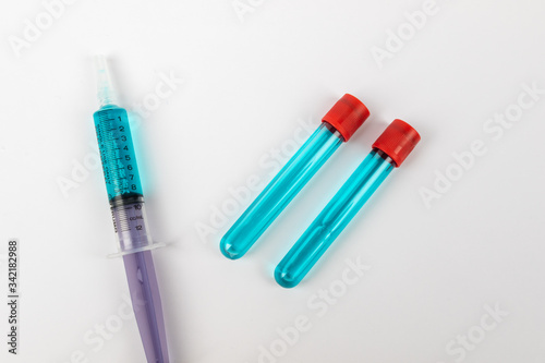 Medical test tube with blue liquid on white background