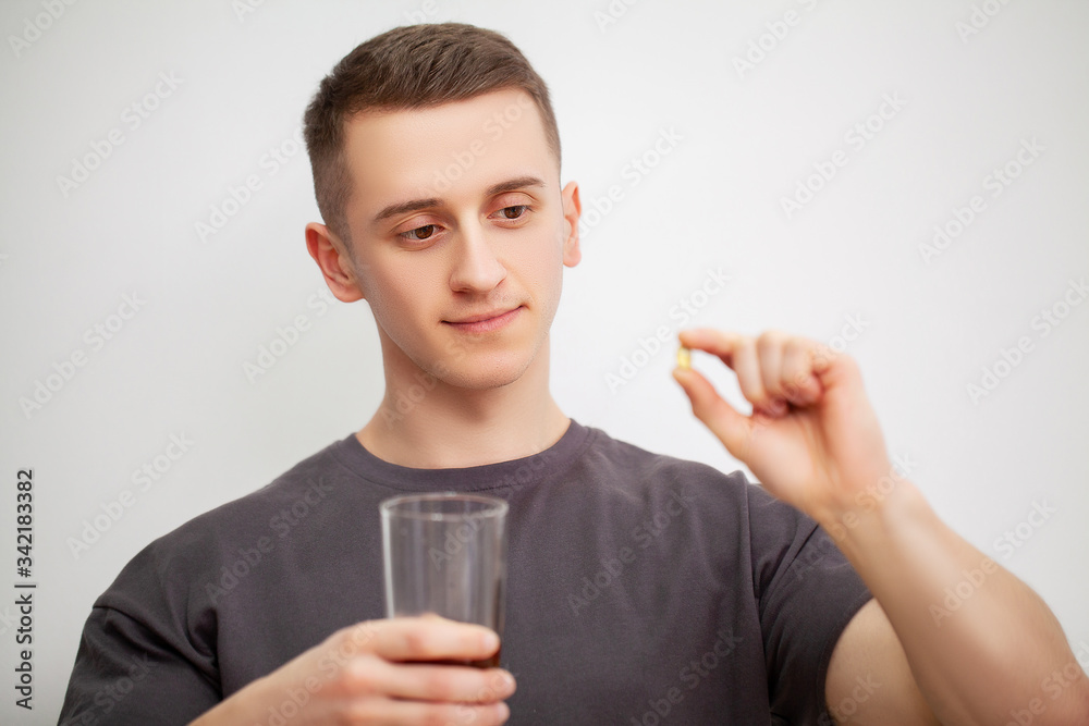 Man takes a pill of amino acids after training. Man takes a pill of amino acids after training.