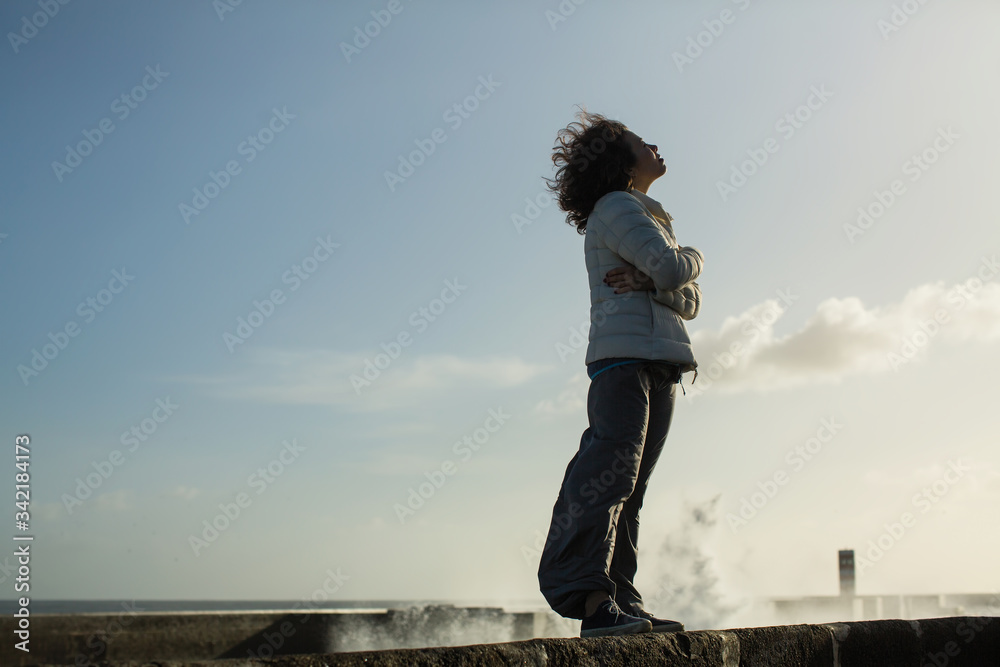 Young multicultural asian female stands on the sea promenade. Young multicultural asian female stands on the sea promenade.