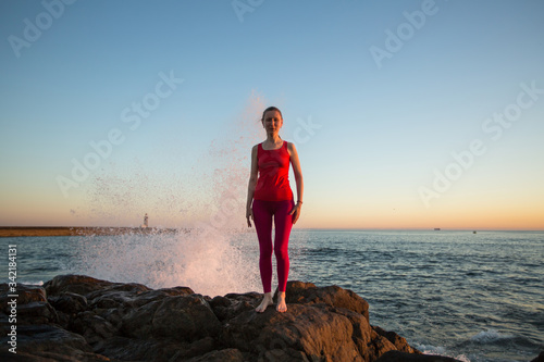 Woman prepares before yoga classes on the atlanic ocean coasts. photo