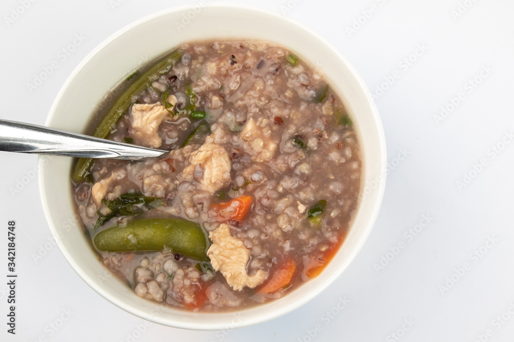 Delicious homemade brown rice porridge with few slice chicken, carrot and vegetable isolated on white background. Delicious homemade brown rice porridge with few slice chicken, carrot and vegetable isolated on white background.