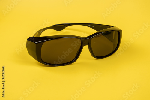 Image of Sunglasses isolated on yellow background.