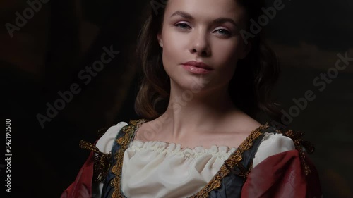 Portrait of a young woman in the style of a Renaissance painting. Beautiful mysterious girl in medieval dress photo