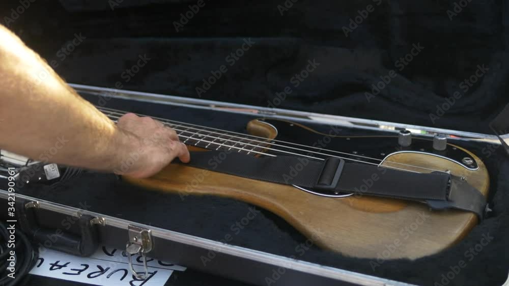 Guitarist puts his guitar in its case after the show