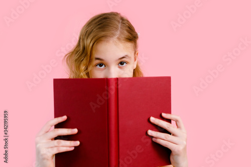 Photo of happy charming blonde girl posing with exercise books and smiling isolated over pink background