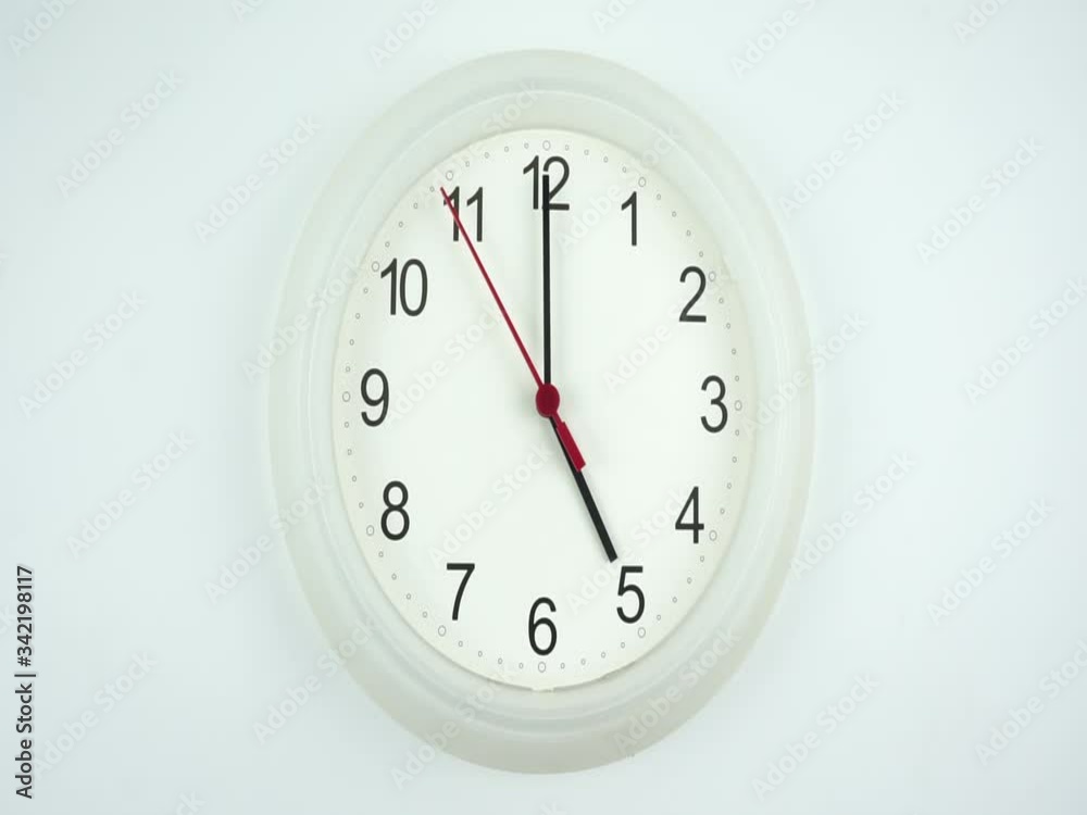 White wall clock on white background, face beginning of time 05.00 am or pm, Clock minute walk slowly, Time concept. White wall clock on white background, face beginning of time 05.00 am or pm, Clock minute walk slowly, Time concept.