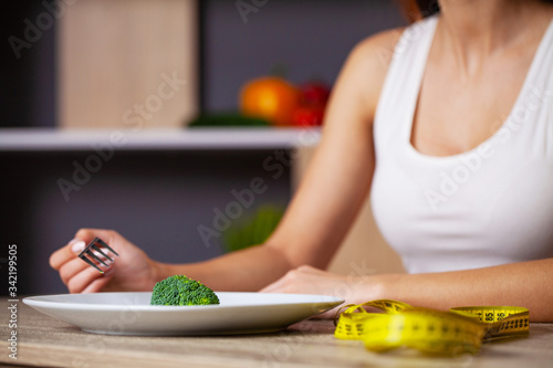 Concept of overweight woman eating broccoli diet.