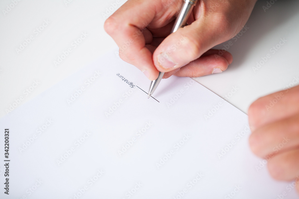 Businessman sitting at office desk signing contract Businessman sitting at office desk signing contract