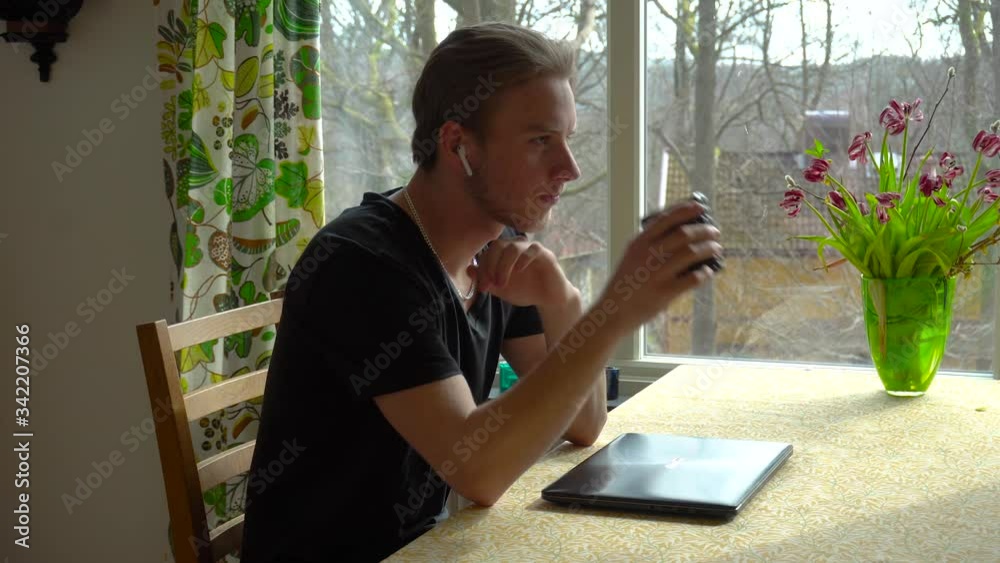 Confident and casual young adult entrepreneur comes up with an idea in his home office, smiles and gets to work. Confident and casual young adult entrepreneur comes up with an idea in his home office, smiles and gets to work.