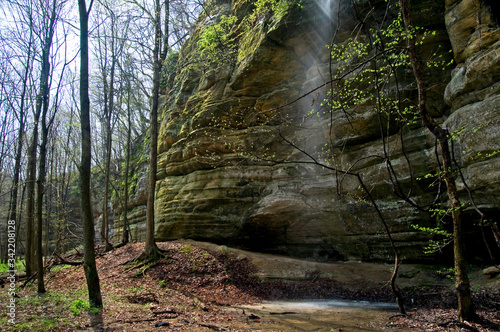 Spring runoff flows over the side of a sandstone canyon wall.