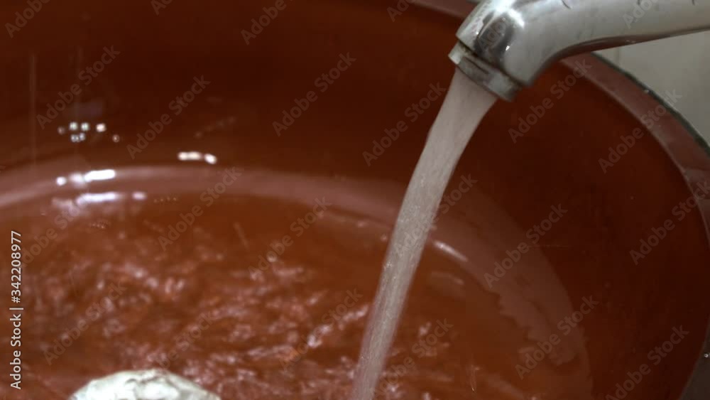 Close up of hands holding water in orange sink Close up of hands holding water in orange sink