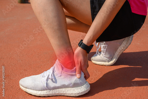 Cropped shot of woman runner suffering from ankle pain. Ankle pain may be caused by an injury, like a sprain, or by a medical condition, such as arthritis.