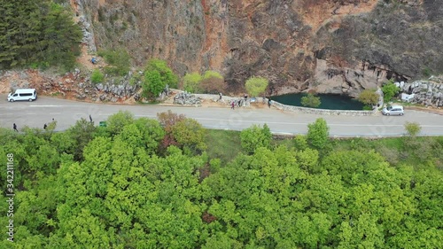 Tourists on road on top of cliff next to the red lake, Imotski, aerial fly over photo