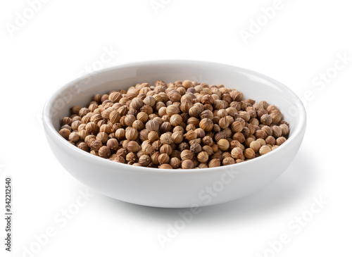 Coriander seeds in a plate placed on a white background