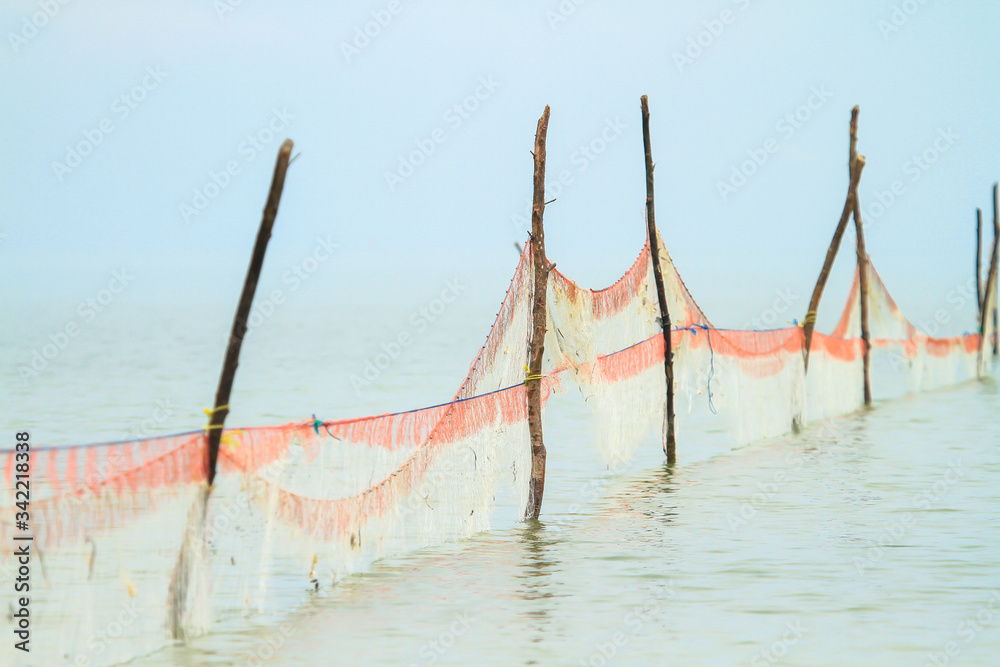 Nets that fishermen use to block and trap fish in traditional fisheries. Fishing with nets set up with wooden poles on the coast. Nets that fishermen use to block and trap fish in traditional fisheries. Fishing with nets set up with wooden poles on the coast.