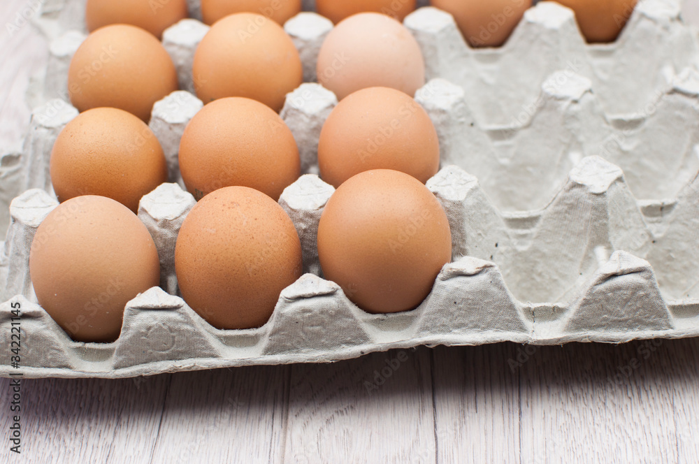 Bunch of raw chicken eggs in carton box. There are no marks on the eggs. Space for text