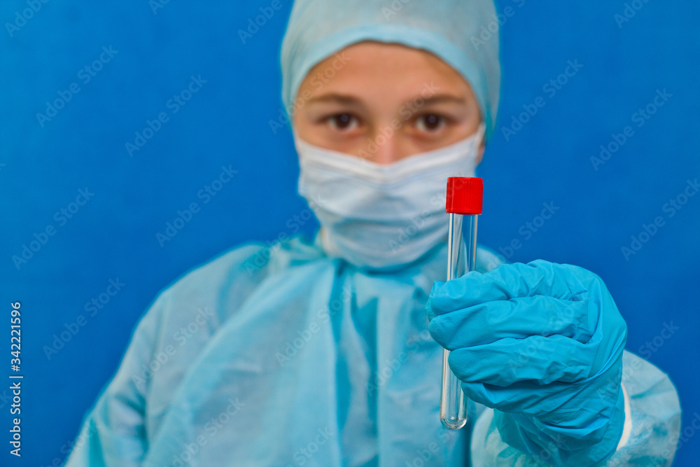 Female medical worker holding test tube on a blue background. Coronavirus test. Female medical worker holding test tube on a blue background. Coronavirus test.