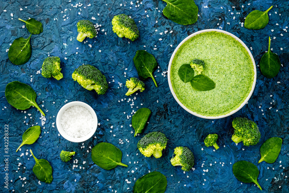 Broccoli and spinach cream soup on blue desk top view. Vegetable pattern Broccoli and spinach cream soup on blue desk top view. Vegetable pattern