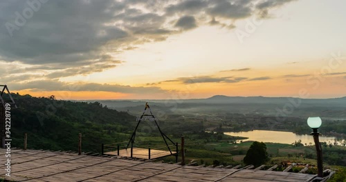 High view Time lapse Landscape Sunset with mountain, hill with trees, blue sky with mist.