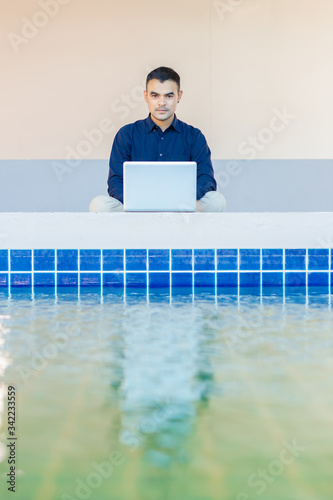 young asia business man, Happy young man working on laptop,at his working from home,Mock up copy space,Beside the pool