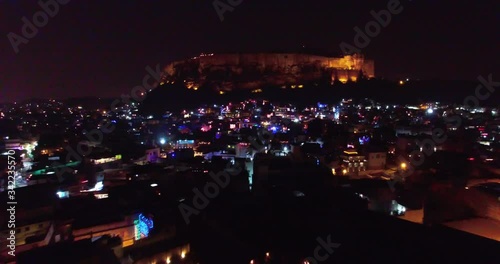 Drone view in Jodhpur, Rajistan India of the blue city, looking at the geological rock formation built into a fort called Mehrangarh or Mehran Fort. Zoom out shot during Diwali festival photo