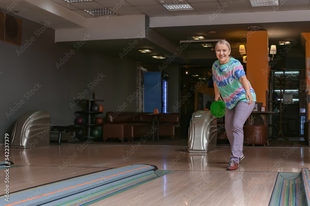 Obraz premium Senior woman playing bowling in club
