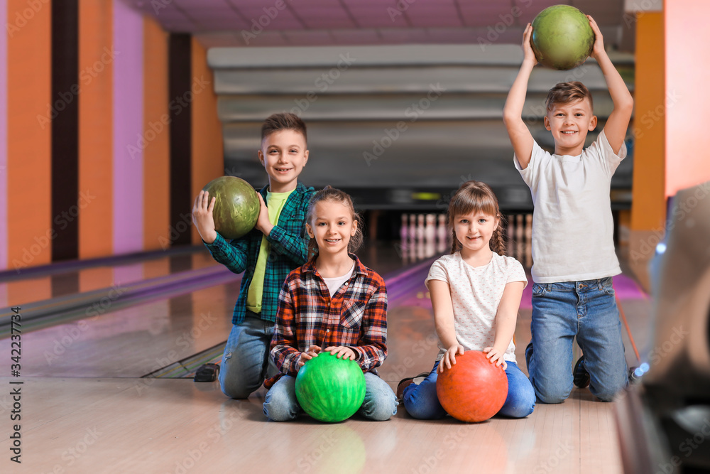 Fototapeta premium Little children playing bowling in club