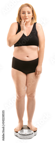 Sad overweight woman with scales on white background. Weight loss concept