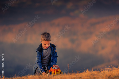 A small child plays with a car