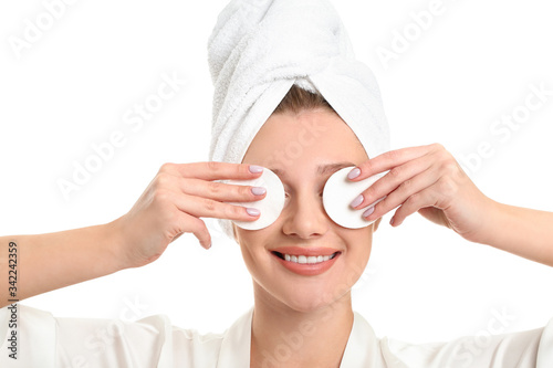Beautiful young woman with cotton pads on white background