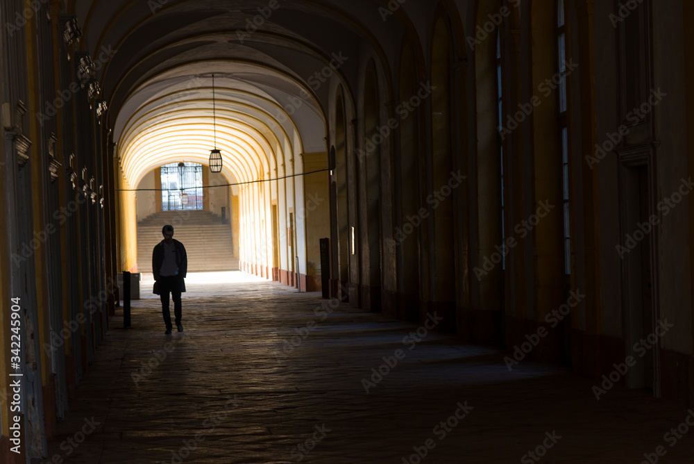 un homme marchant dans  un corridor sombre